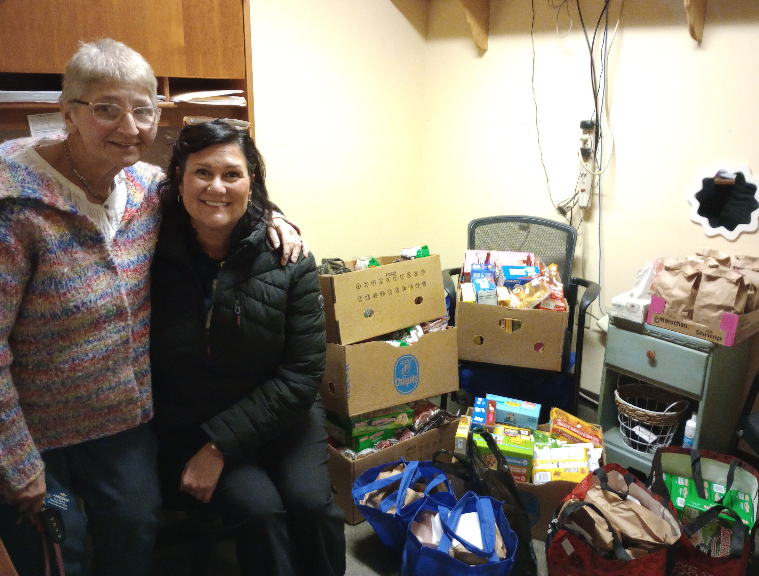 Joey Monn is pictured with Mental Health Association (MHA) Project Manager Shannon Fisk and the many bags and boxes of food and hygiene products Monn donated to share with MHA participants. 