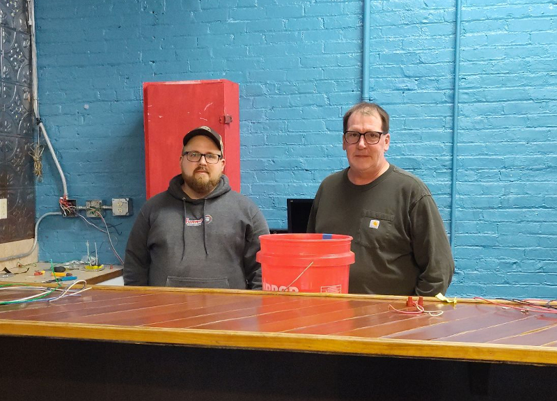 Apprentice Steve McIntyre (left) and a journeyman (not pictured) from IBEW Local 106 Electricians Union volunteered their services to the Mental Health Association by removing and replacing receptacles that are used for monthly recovery luncheons. McIntyre is pictured with retiree Jeff Marsh, who coordinated the volunteer event.